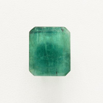 Lot 311 - AN EMERALD-CUT EMERALD SINGLE STONE