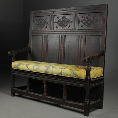Lot 691 - OAK SETTLE WITH CARVED PANELLED BACK.